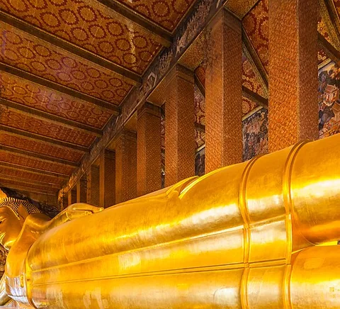 The reclining Buddha beneath richly decorated Wat Pho walls.